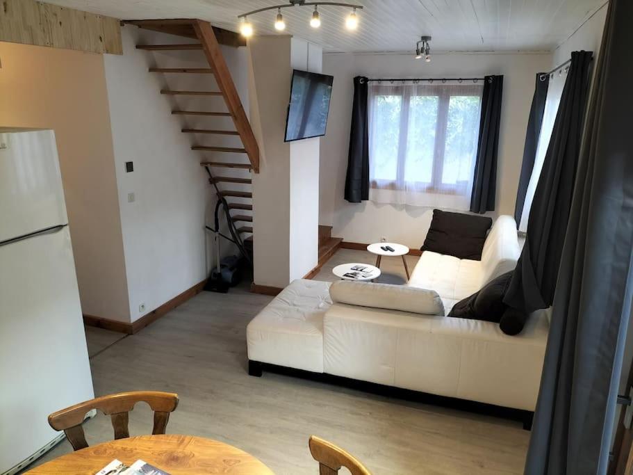 a living room with a white couch and a staircase at A découvrir Superbe Maison Calme et Lumineuse in Vallouise