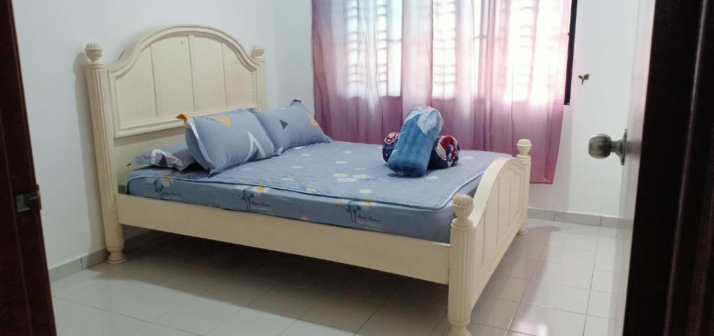 HOMESTAY BUDGET MASJID TANAH PERDANA في مسجد طنة: سرير صغير في غرفة مع سرير أطفال