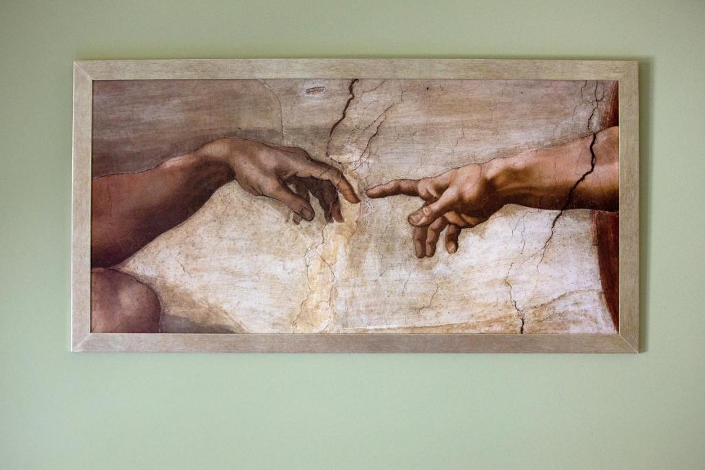 una pintura de dos manos en una pared en Casa Kastropolis en Ioánina