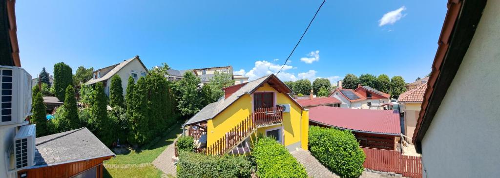 widok na miasto z żółtym domem w obiekcie Pink Tulip Apartment House w Siófoku