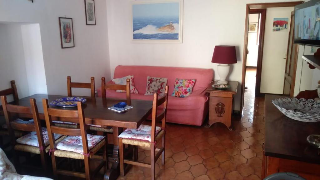 a living room with a table and a pink couch at Casa Lenzi in Portoferraio