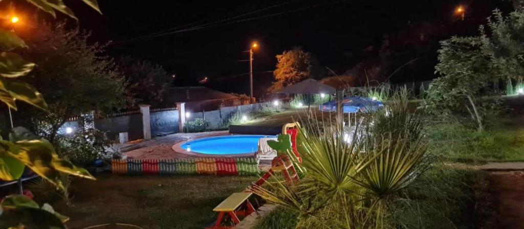 a backyard at night with a swimming pool and lights at Sunshine villa Dzhigurovo in Sandanski