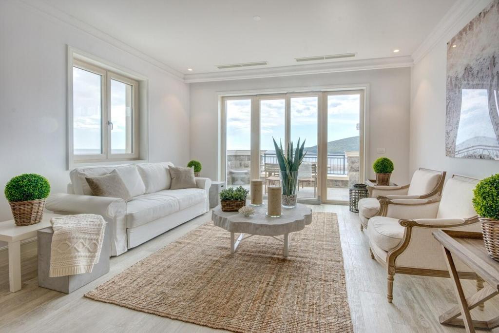 uma sala de estar com um sofá branco e uma mesa em Lustica Bay Apartment Maria By 2bhome em Radovići