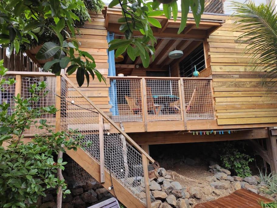 聖魯的住宿－Bungalow écologique avec toilettes sèches LEU KABANON vue mer，坐在树屋甲板上的狗