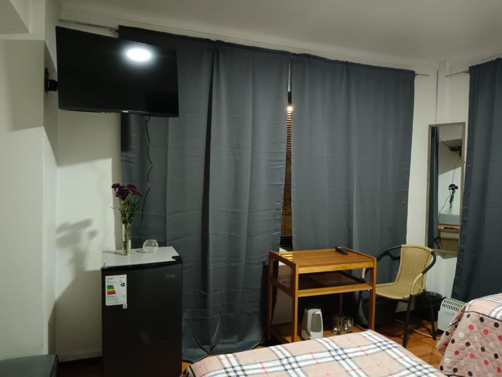 um quarto com uma cama, uma televisão e uma mesa em Donde Gabriel em Chillán