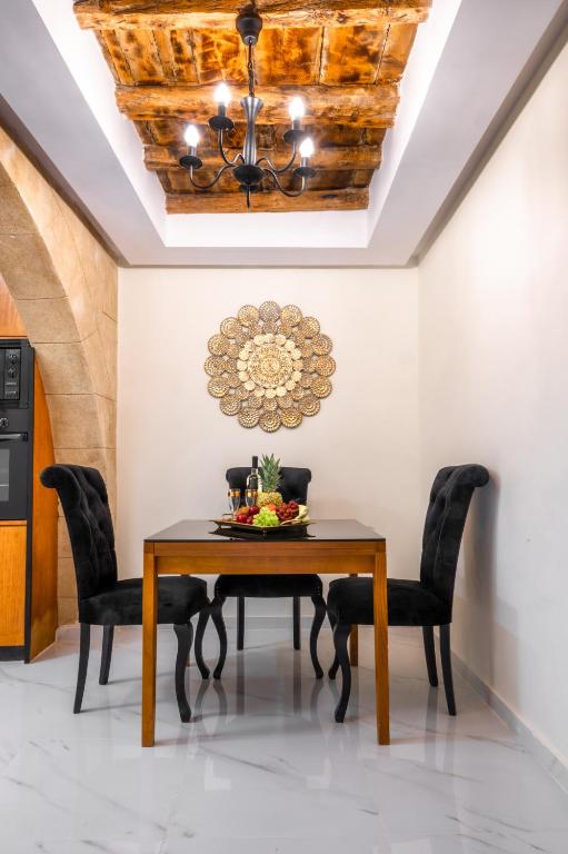 a dining room table with chairs and a chandelier at Odysseus Luxury House in Rhodes Town