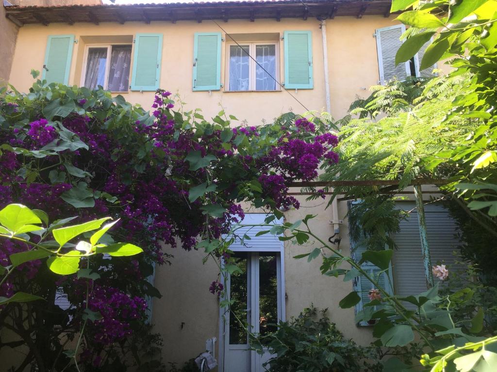 une maison avec des fleurs violettes devant dans l'établissement Maison au calme avec jardin et garage proche du centre et de la mer, à Cannes