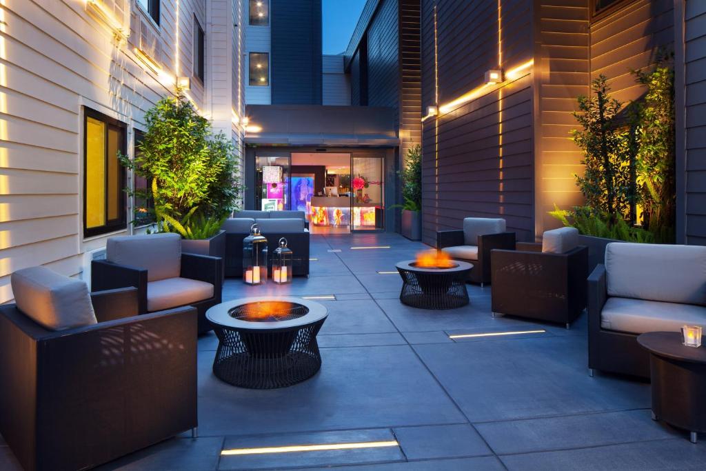a patio with couches and tables on a building at Aloft Sunnyvale in Sunnyvale