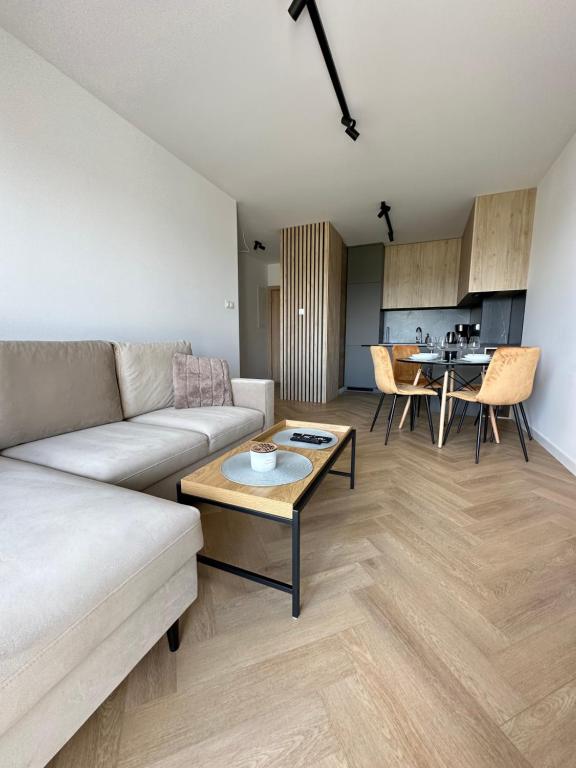 een woonkamer met een bank en een tafel bij Apartament Widokowy Zamkowa in Tczew