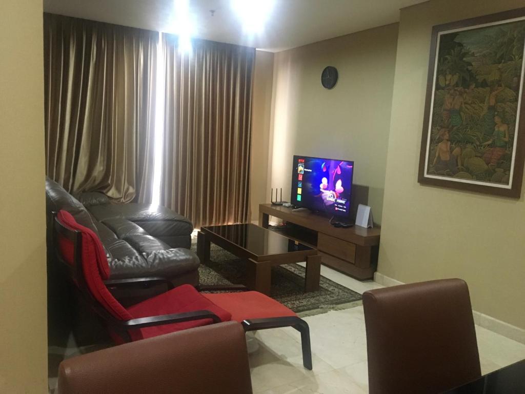 sala de estar con sofá y TV en Luxury 2 BR Suite at The Grove-Masterpiece, Epicentrum, en Yakarta