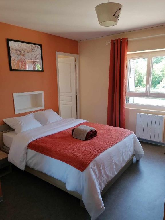 een slaapkamer met een groot bed en een rode deken bij le valoria delph et greg 