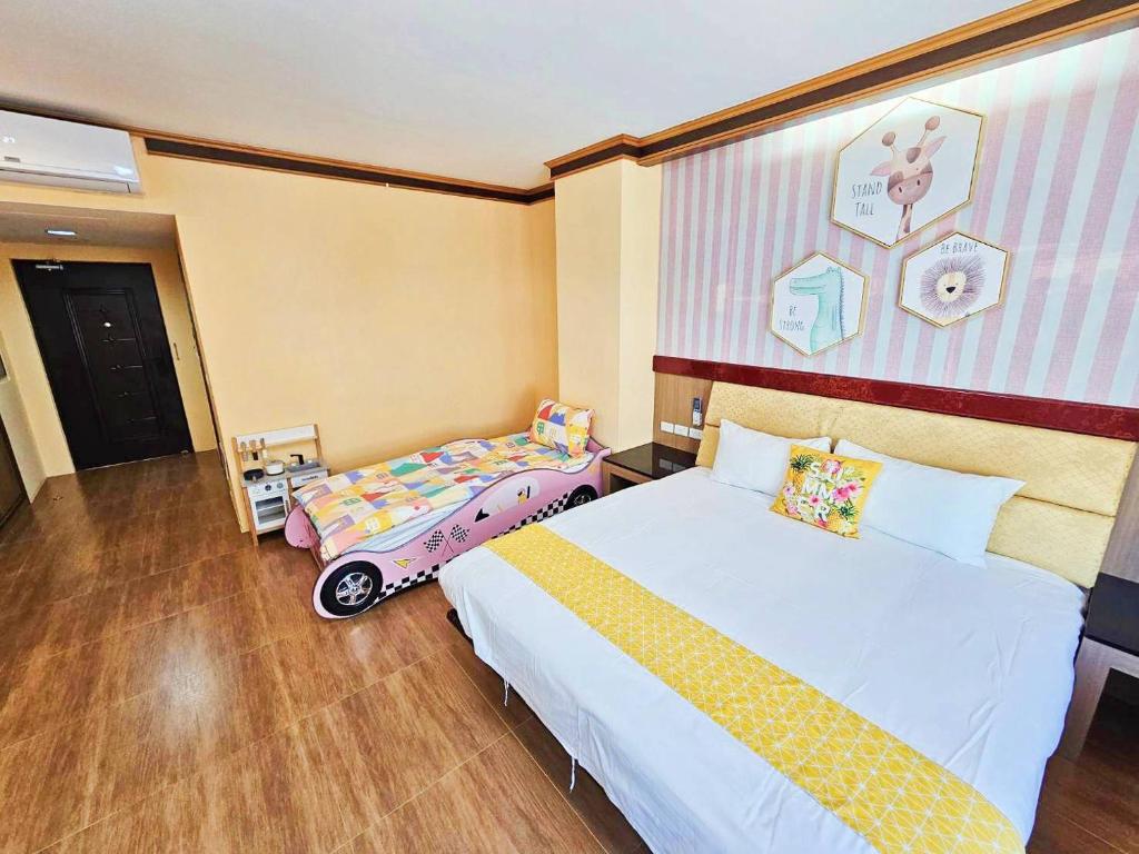 a bedroom with two beds and a wall with a mural at 恆春古城親子民宿 in Hengchun South Gate