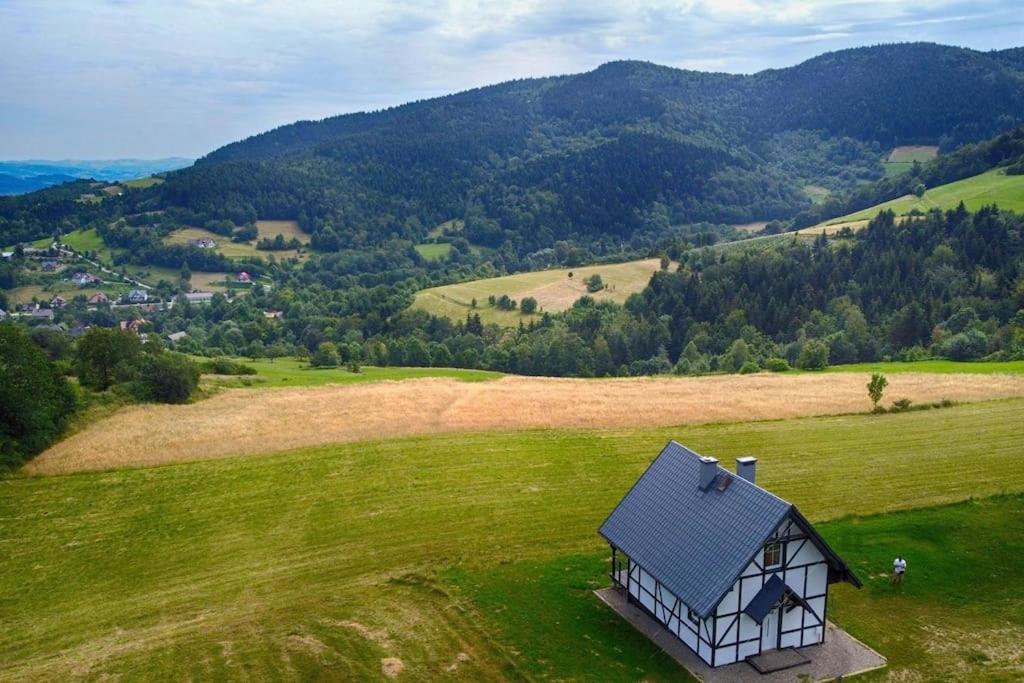 a small house in the middle of a green field at Wyspa Zdarzeń - klimatyczny dom w sercu natury! in Żmiąca