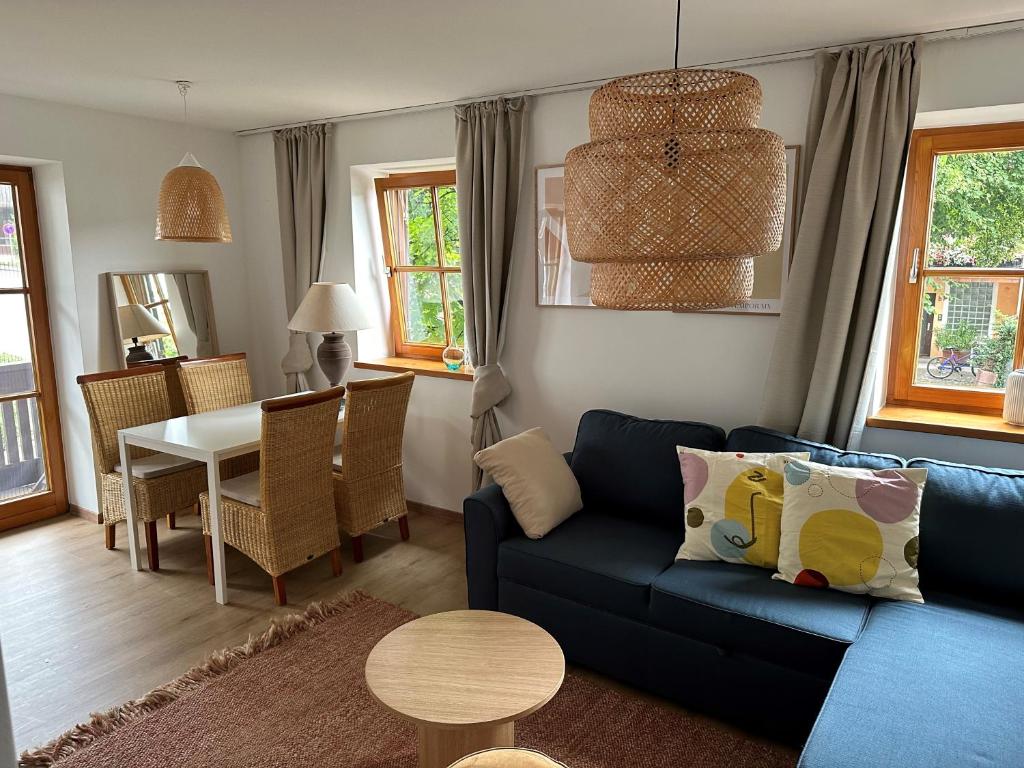 a living room with a blue couch and a table at Seeapartment in Prien am Chiemsee