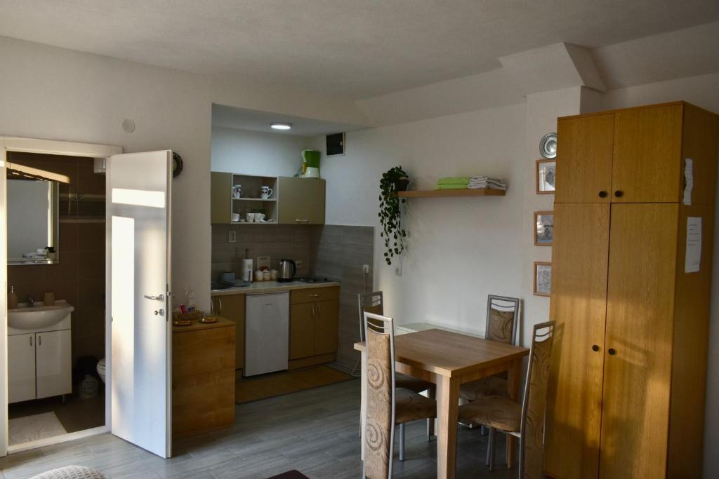a kitchen with a table and a dining room at Petković apartman in Bajina Bašta