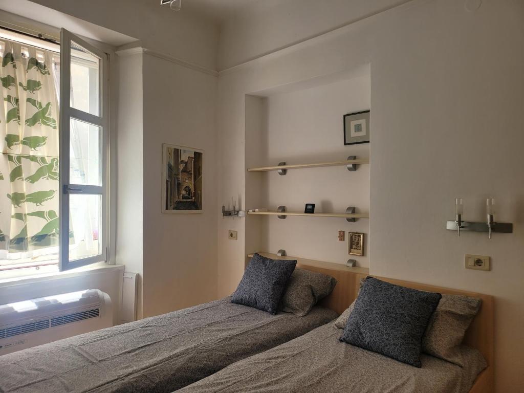 a bedroom with a bed with two pillows and a window at Studio Labirint in Piran