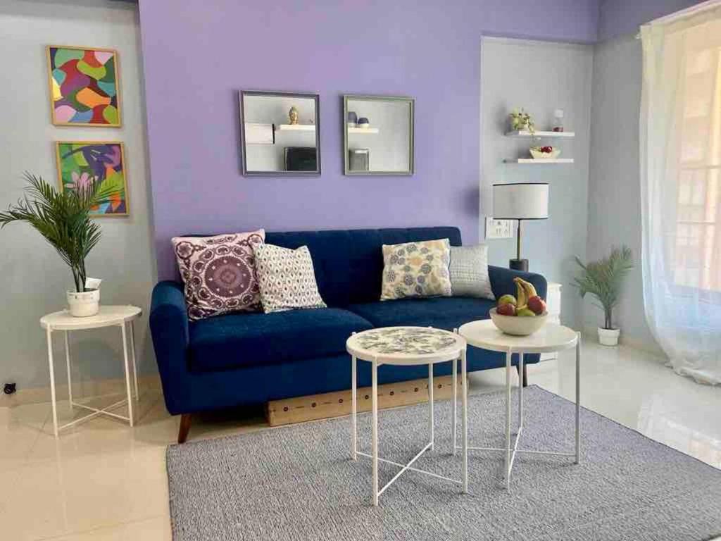 Pali Carters Building 801, 20th Road, Khar West by Connekt Homes في مومباي: غرفة معيشة مع أريكة زرقاء وطاولة
