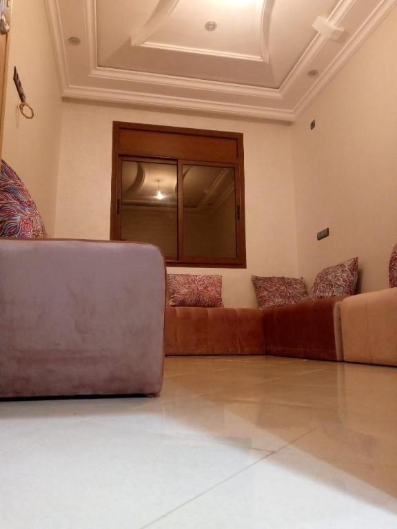 Ouma yanis في القنيطرة: غرفة معيشة مع كنب بني في غرفة