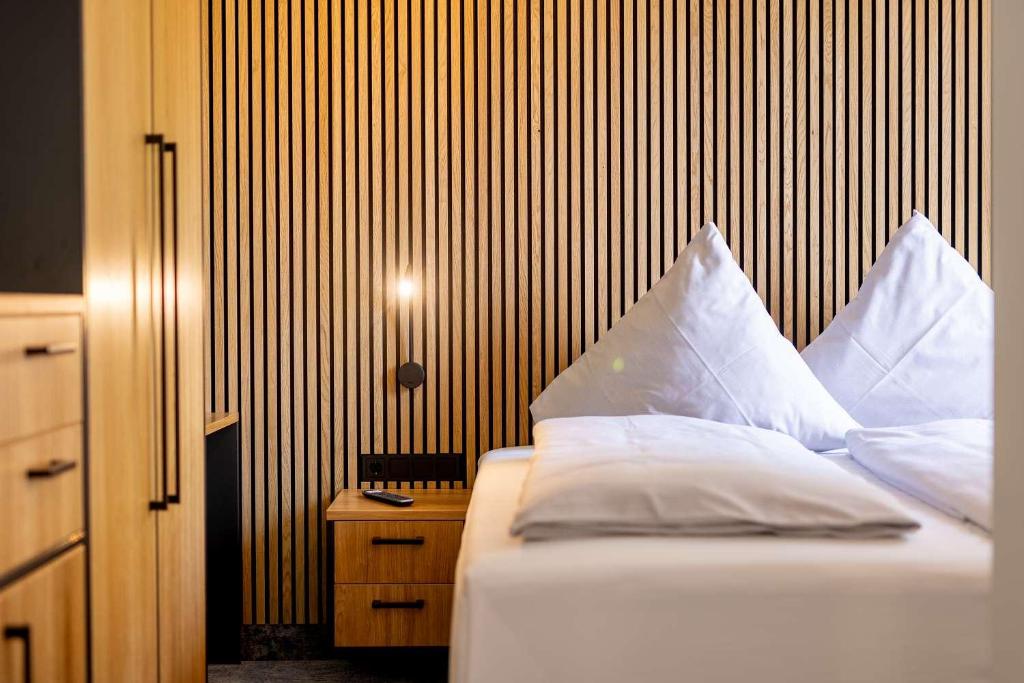 a bedroom with a bed with white pillows on it at Hotel Südblick in Norderney