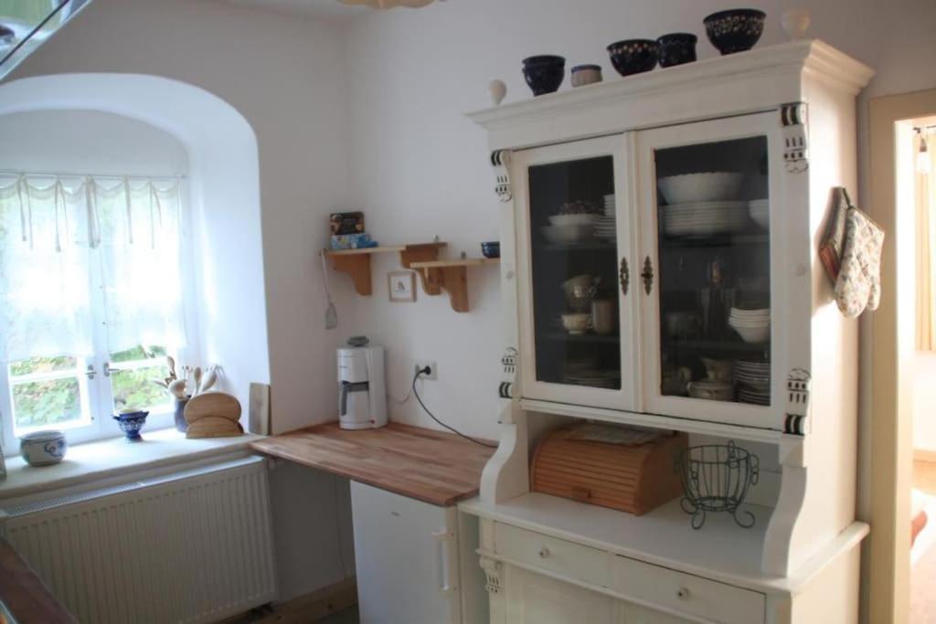 a kitchen with white cabinets and a window at Hofmühle Pfaffroda-Ferienwohnung Am Mühlbach in Olbernhau