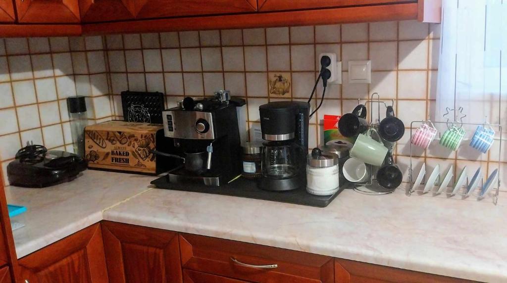 a kitchen counter with a coffee maker on a counter top at Thira Apartment near Athens Airport in Spata