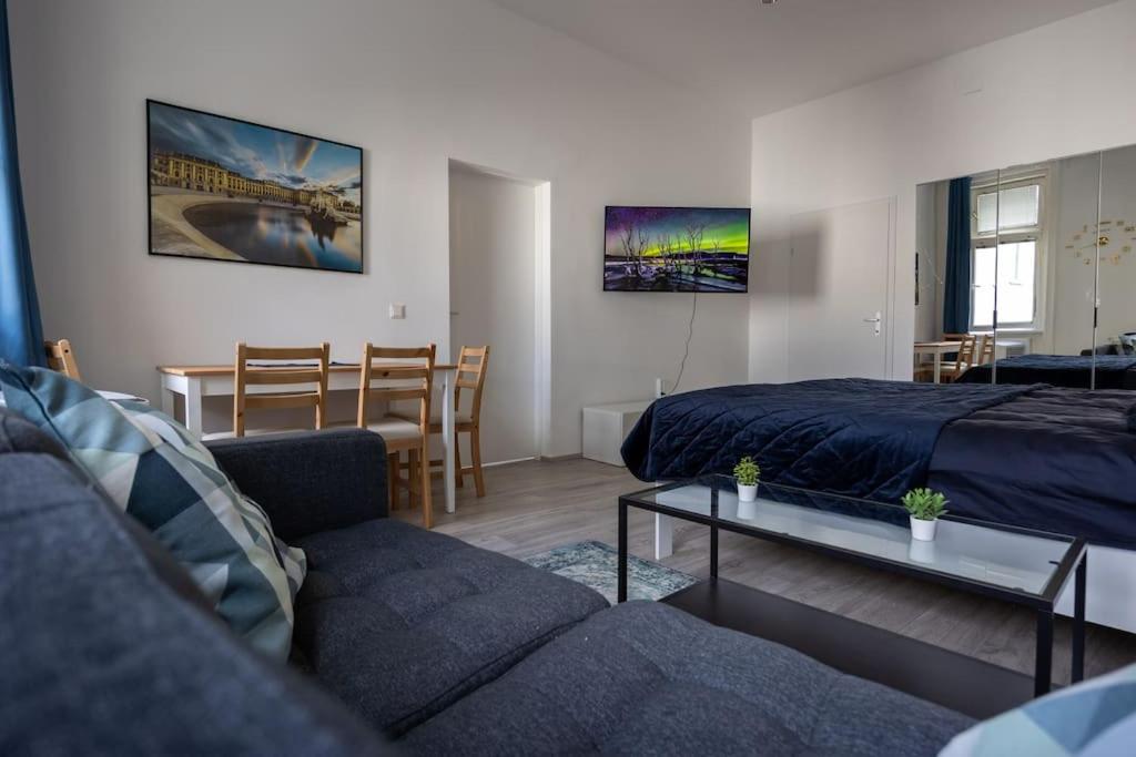 un salon avec un lit, un canapé et une table dans l'établissement Royal Blue Deluxe, à Vienne