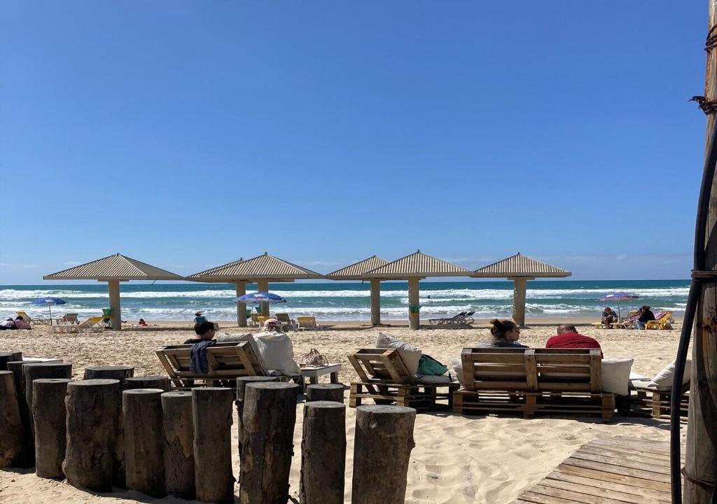 a group of people sitting in chairs on a beach at Studio near the sea in Netanya