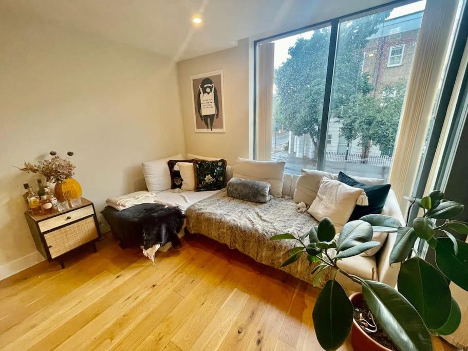 a living room with a bed and a large window at Modern 1 King Size Apartment in Angel near canal in London