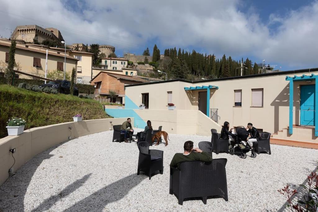 een groep mensen die in stoelen op een binnenplaats zitten bij Il Guernico appartamenti in Volterra