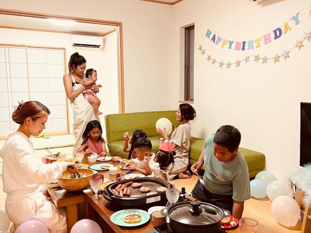 a group of people sitting around a table eating food at iruka - Vacation STAY 83037v in Nago