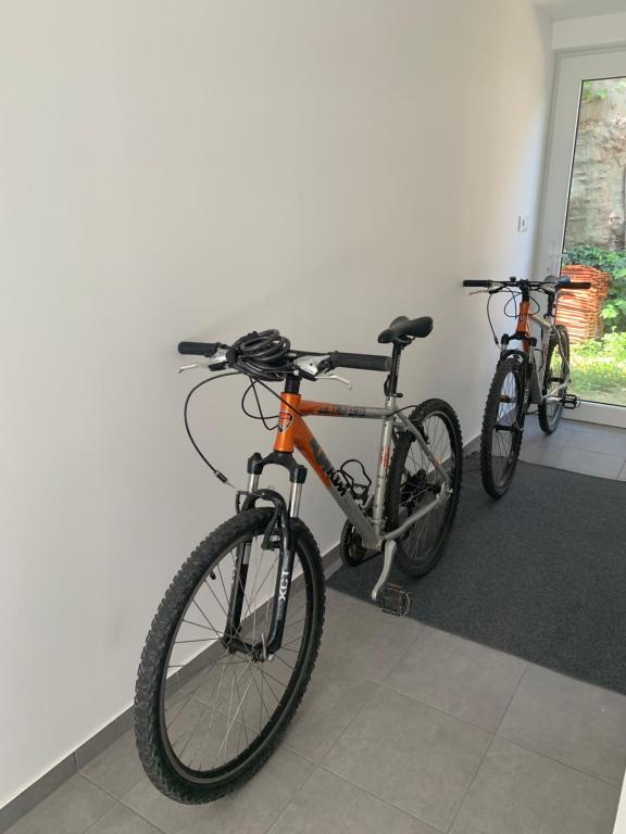 duas bicicletas estão estacionadas ao lado de uma parede em Sicomoro Casa em Sopron