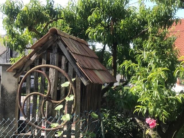 een houten vogelhuisje bovenop een hek bij Puskás vendégház 