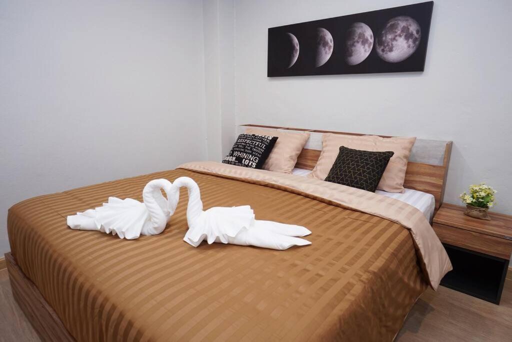 two white swans are sitting on a bed at Maruay Living Apartment 510 (Khaosan/Chinatown/Samyot MRT) in Bangkok