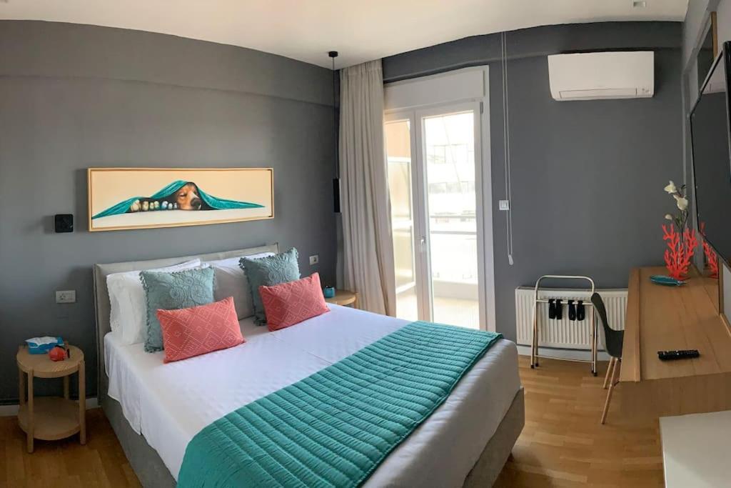 1 dormitorio con 1 cama grande y almohadas coloridas en Above & Beyond Volos City Center Luxury Redefined, en Volos
