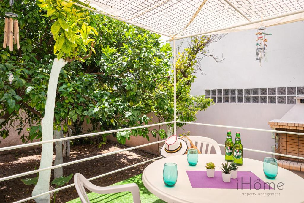 畢達哥利翁的住宿－I Love Samos - Maisonette at the heart of Pythagorio，庭院配有桌椅和遮阳伞。