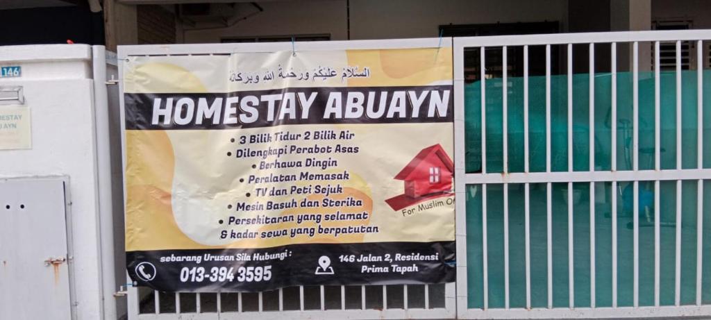 a banner hanging on a fence next to a pool at Homestay Abu Ayn Islam in Tapah