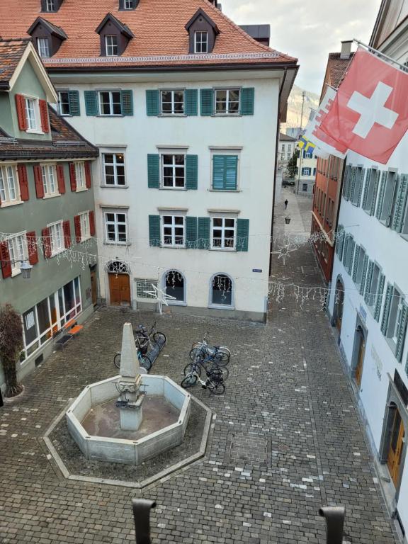 a building with a fountain in the middle of a courtyard at Zunfthaus zur Rebleuten in Chur
