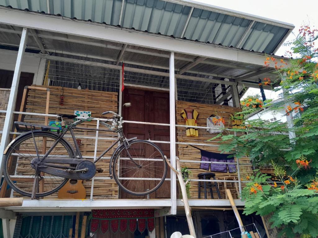 een fiets geparkeerd aan de zijkant van een huis bij Pikban in Chiang Rai