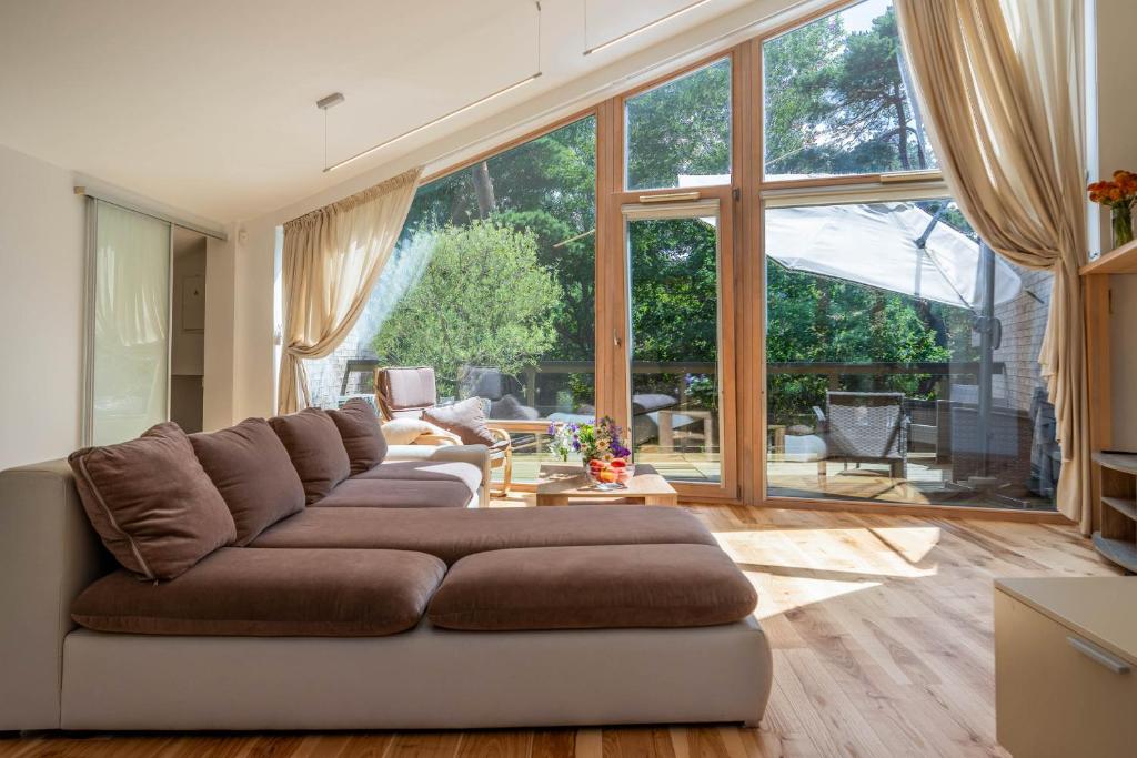 a living room with a couch and a large window at Anbo Vila in Palanga