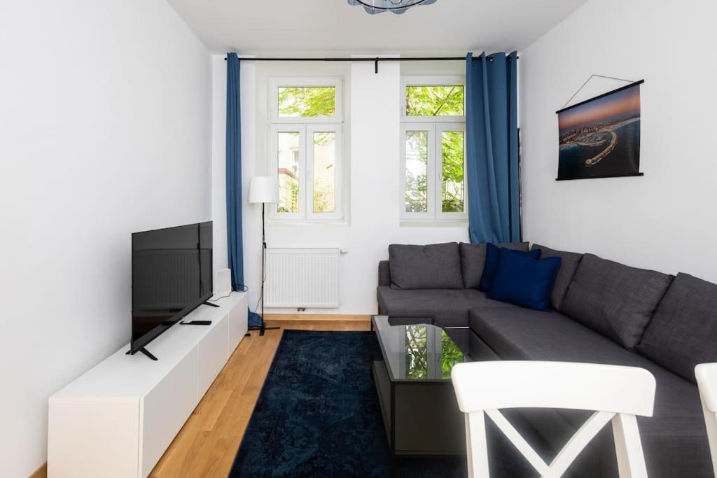uma sala de estar com um sofá e uma televisão em Simply Serene em Viena