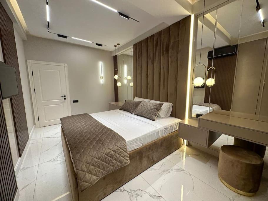 a bedroom with a bed and a vanity and a mirror at Levent beach 1,Luxury apartment in Sumqayyt