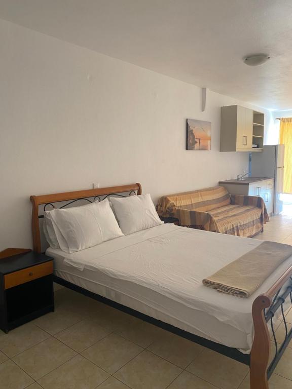 una camera con un grande letto e una cucina di Sisamis Studios Pigadia Karpathos a Karpathos