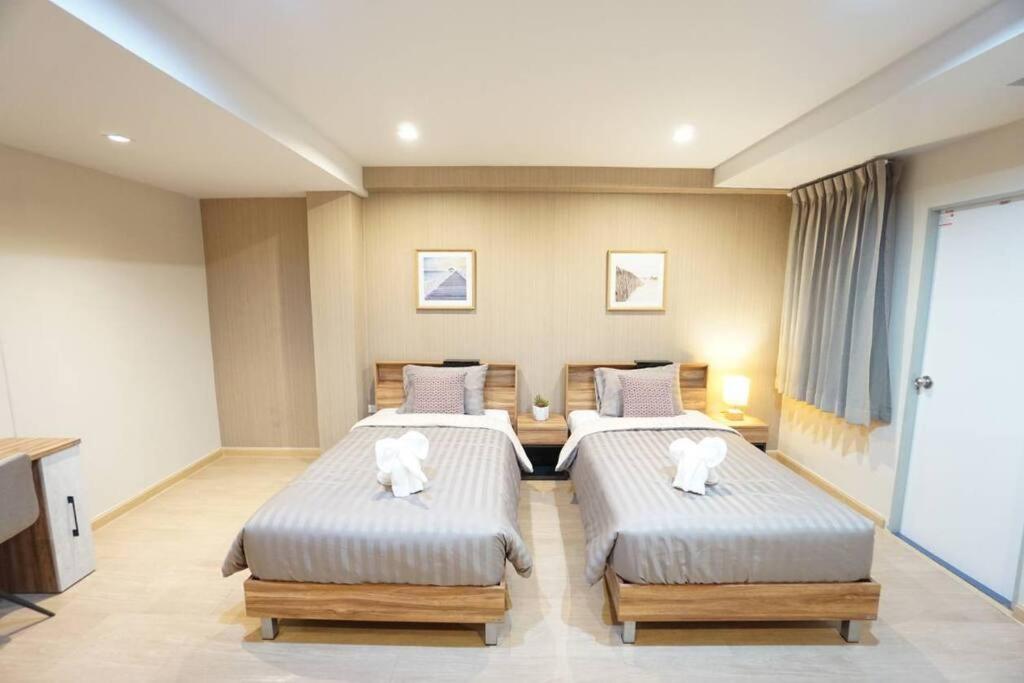 a bedroom with two beds with white towels on them at Maruay Living Apartment 509 (Khaosan/Chinatown/Samyot MRT) in Bangkok