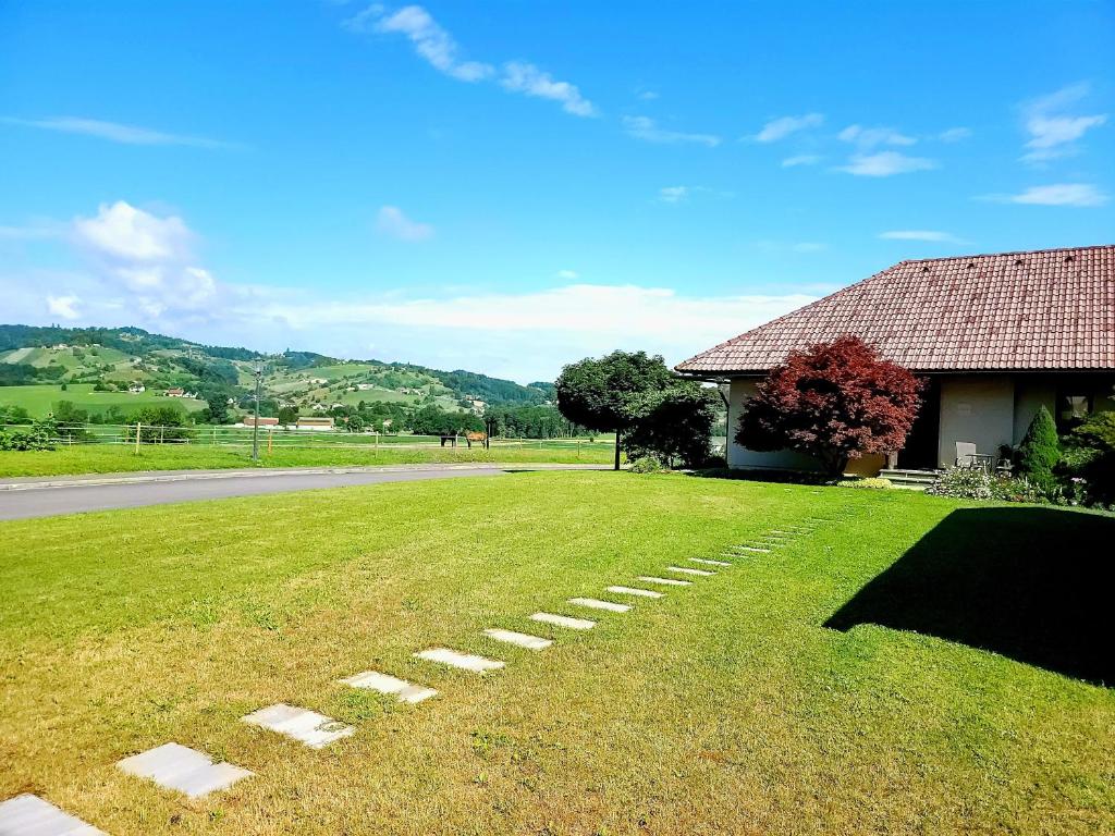 un patio de césped junto a una casa y una carretera en Apartma Stanka, en Bistrica ob Sotli