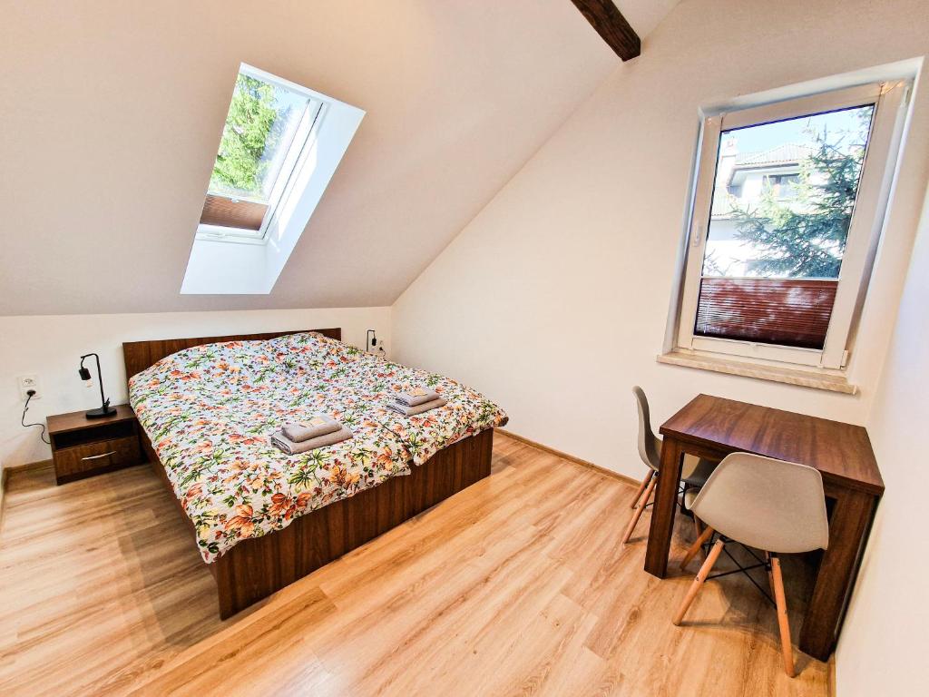 um quarto com uma cama, uma secretária e uma janela em GraVelo - Noclegi em Bartkowa-Posadowa