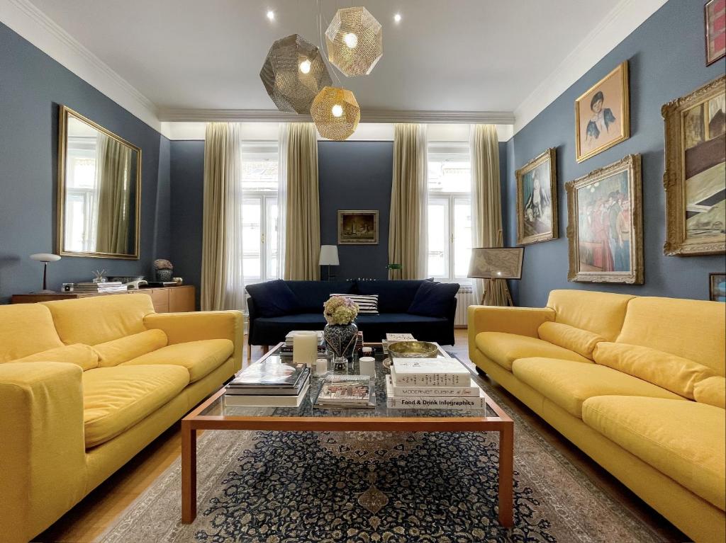 a living room with yellow couches and a coffee table at 3 Bedroom apartment Zagreb center in Zagreb