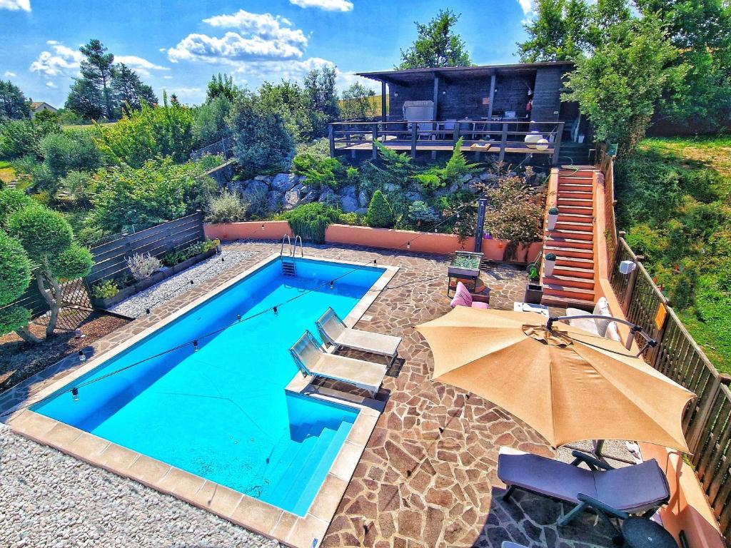 a swimming pool with two chairs and an umbrella at W a n d e r l u s t - casa con piscina riscaldata ad uso esclusivo - Marche in Rustico