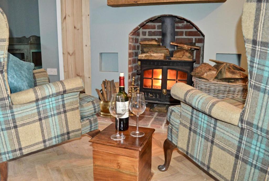 a living room with two couches and a fire place at Skylarks - Cley next the Sea - Crabpot Cottages. in Cley next the Sea