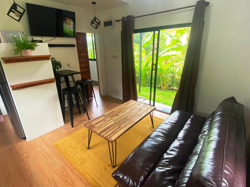 un soggiorno con divano in pelle e tavolo di S&S House a Srithanu Beach
