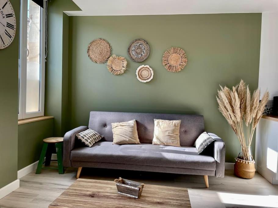 - un salon avec un canapé et des assiettes murales dans l'établissement Appartement chaleureux aux portes de Bordeaux, à Macau